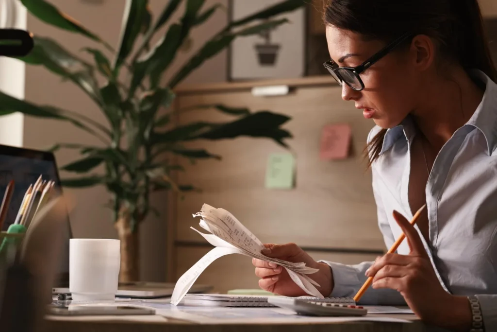 жінка-бухгалтер розраховує податкові рахунки під час роботи над фінансами в офісі