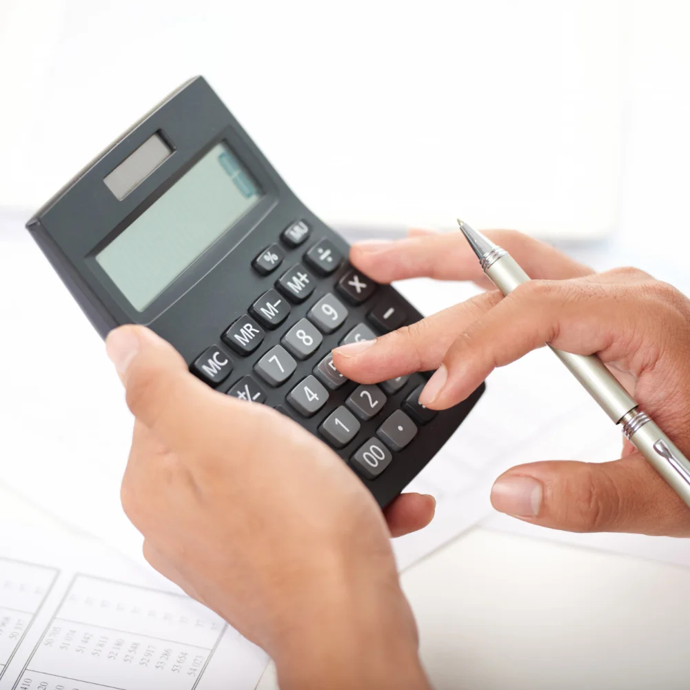 офісний працівник перераховує податки на калькуляторі